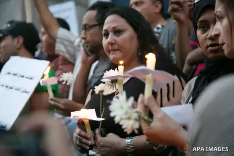 Egyptian journalists hold candles and placards supporting EgyptAir during a candlelight vigil for the victims of EgyptAir flight 804 in front of the Journalists' Syndicate in Cairo, Egypt, on May 24, 2016. The cause of T...