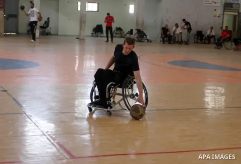 An American coach Jess marc, trains disabled Palestinians to play a basketball in Khan Younis in the southern Gaza strip, on May 26, 2016. Photo by Abed Rahim Khatib