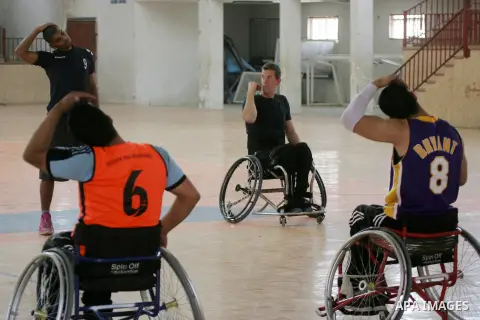 An American coach Jess marc, trains disabled Palestinians to play a basketball in Khan Younis in the southern Gaza strip, on May 26, 2016. Photo by Abed Rahim Khatib