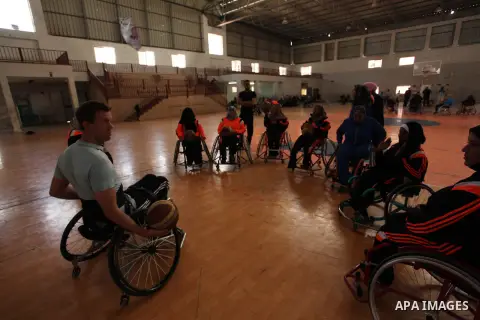 An American coach Jess marc, trains disabled Palestinians to play a basketball during a training course organised by the Palestinian Red Cross, in Khan Younis in the southern Gaza strip, on May 28, 2016. Photo by Ashraf...