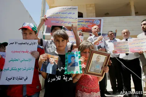 Palestinians take part in a protest to solidarity with the prisoners in Israeli jails, in front of Red cross office, in the West Bank city of Hebron, on May 30, 2016. Photo by Wisam Hashlamoun