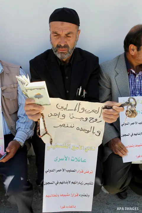 Palestinians take part in a protest to solidarity with the prisoners in Israeli jails, in front of Red cross office, in the West Bank city of Hebron, on May 30, 2016. Photo by Wisam Hashlamoun