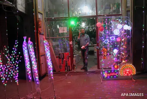 Palestinian man stand outside his shop during hang up decorations before the holy month of Ramadan in the Rafah refugee camp in southern Gaza Strip on May 30, 2016. Photo by Abed Rahim Khatib