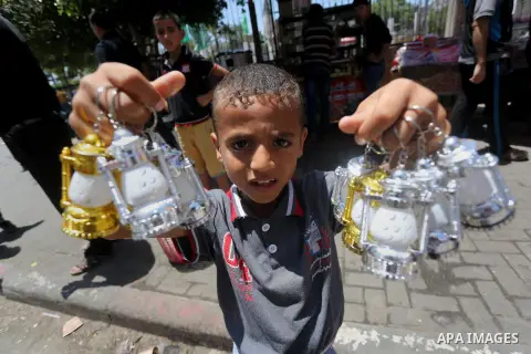 A Palestinian boy holds a traditional lantern known in Arabic as "Fanous" in a market in Gaza city as the faithful prepare for the start of the Muslim holy fasting month of Ramadan on May 31, 2016. More than 1.5 billion...