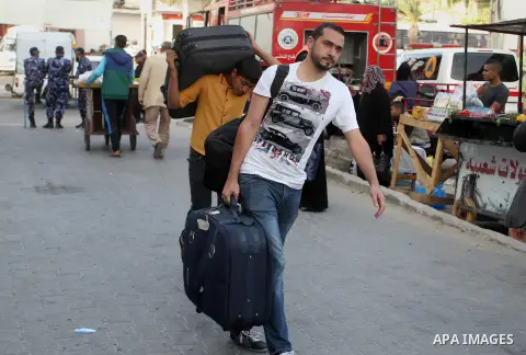 Palestinians wait for travel permits to cross into Egypt through the Rafah border crossing after it was opened for four days by Egyptian authorities, in the southern Gaza Strip June 1, 2016. Photo by Abed Rahim Khatib