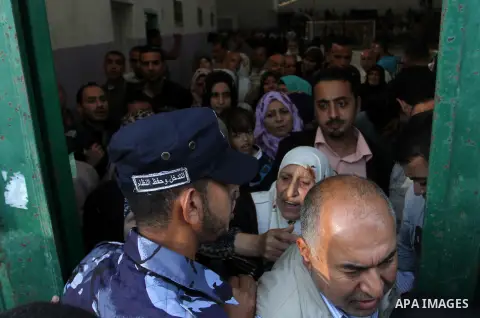 Palestinians wait for travel permits to cross into Egypt through the Rafah border crossing after it was opened for four days by Egyptian authorities, in the southern Gaza Strip June 1, 2016. Photo by Abed Rahim Khatib