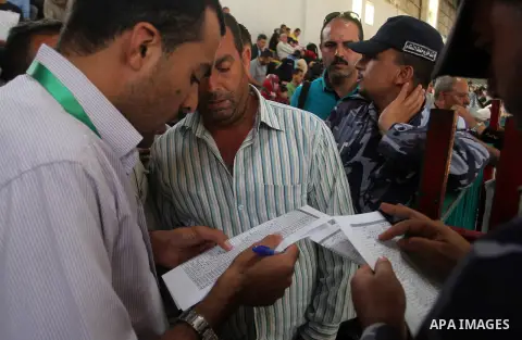 Palestinians wait for travel permits to cross into Egypt through the Rafah border crossing after it was opened for four days by Egyptian authorities, in the southern Gaza Strip June 1, 2016. Photo by Abed Rahim Khatib