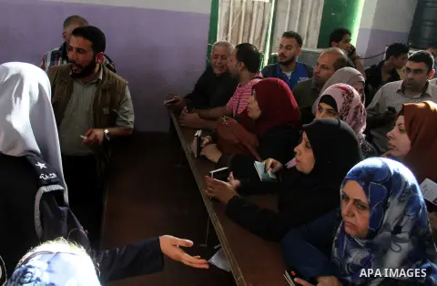 Palestinians wait for travel permits to cross into Egypt through the Rafah border crossing after it was opened for four days by Egyptian authorities, in the southern Gaza Strip June 1, 2016. Photo by Abed Rahim Khatib