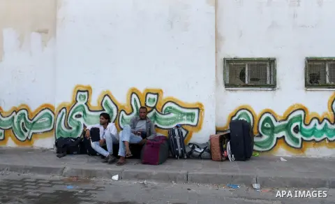 Palestinians wait for travel permits to cross into Egypt through the Rafah border crossing after it was opened for four days by Egyptian authorities, in the southern Gaza Strip June 1, 2016. Photo by Abed Rahim Khatib