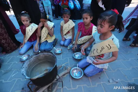 Palestinian children hold banners during a protest to break the siege, at the seaport of Gaza City on 01 June 2016. Photo by Mohammed Asad
