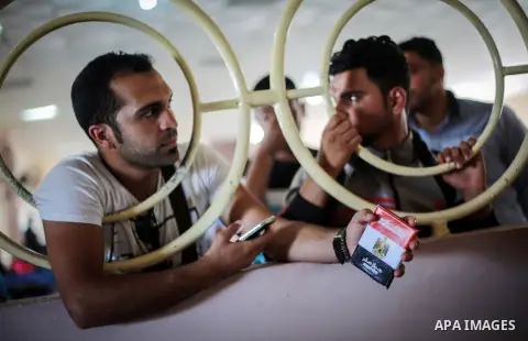 Palestinians wait for travel permits to cross into Egypt through the Rafah border crossing after it was opened for four days by Egyptian authorities, in the southern Gaza Strip June 02, 2016. Photo by Mohammed Dahman