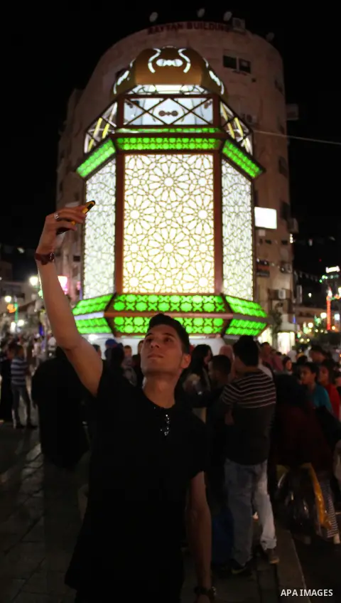 Palestinians celebrate during the ceremony of lighting Ramadan a traditional lantern known in Arabic as "Fanous" in the West bank city of Ramallah, on June 02, 2016. Photo by Hamza Shalash