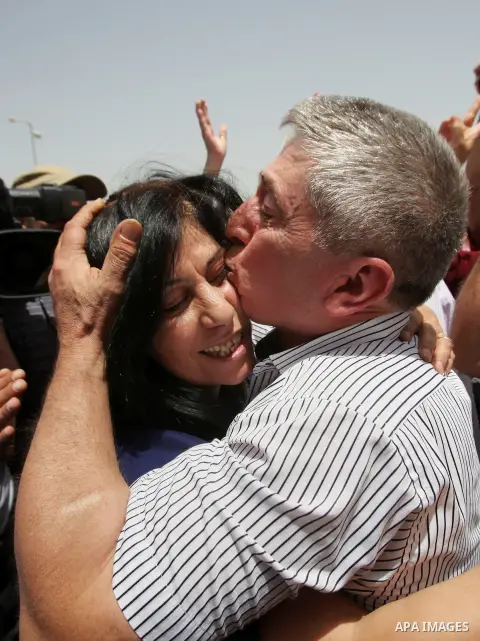 Prominent Palestinian lawmaker Khalida Jarrar hugs her husband at the Jubara checkpoint near the northern West Bank city of Tulkarem, following her release from an Israeli jail on June 3, 2016, after serving a 15-month s...