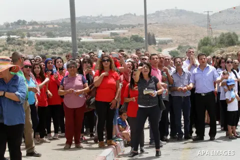 Palestinians look on during Israeli security forces release Prominent Palestinian lawmaker Khalida Jarrar at the Jubara checkpoint near the northern West Bank city of Tulkarem on June 3, 2016, after serving a 15-month se...
