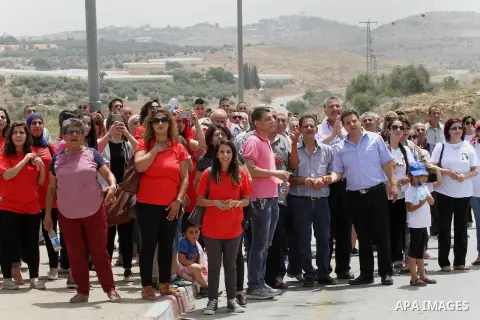 Palestinians look on during Israeli security forces release Prominent Palestinian lawmaker Khalida Jarrar at the Jubara checkpoint near the northern West Bank city of Tulkarem on June 3, 2016, after serving a 15-month se...