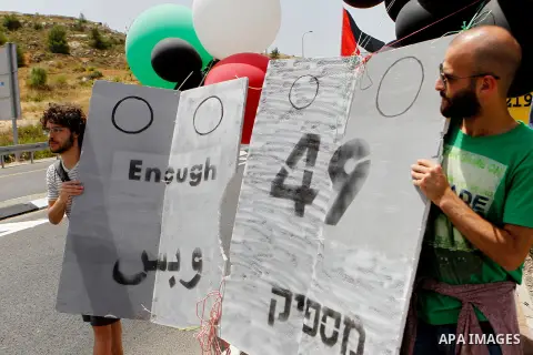 Palestinian and Israeli activists take part in a demonstration in support of peace near the West Bank city of Bethlehem June 3, 2016. Photo by Wisam Hashlamoun