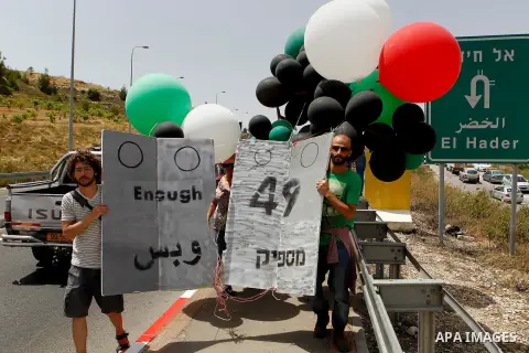 Palestinian and Israeli activists take part in a demonstration in support of peace near the West Bank city of Bethlehem June 3, 2016. Photo by Wisam Hashlamoun