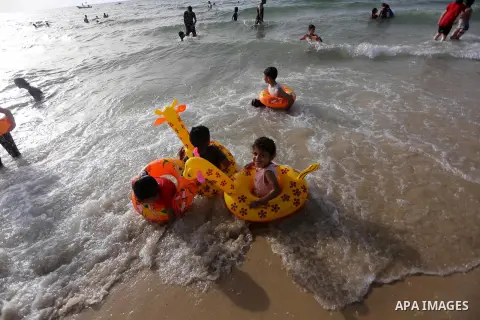 Palestininas swim in the Mediterranean sea on the coast of Gaza city, on June 03, 2016 on the last Friday before the Islamic holy month of Ramadan. Photo by Mohammed Asad