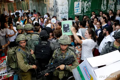 Israeli troops guard Israeli settlers during their weekly tour through the Old City of West Bank city of Hebron, 04 June 2016. Every Saturday a tour through Hebron's Old City, which is usually off limits for Israeli sett...