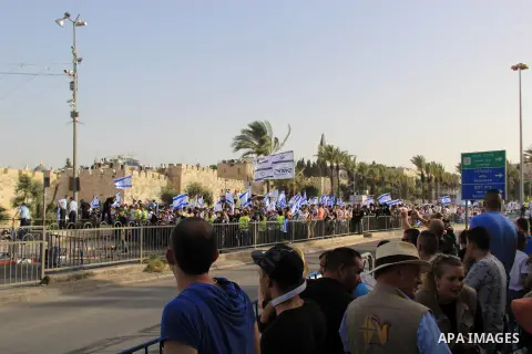 Israelis wave their country's national flags as they take part in an annual march marking Israel's 1967 seizure of the Palestinian-dominated eastern half of Jerusalem, outside Damascus Gate in Jerusalem's old city on Jun...