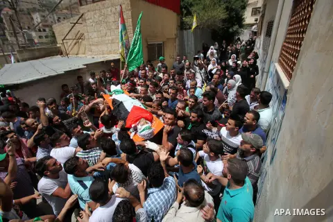 Mourners carry the body of Palestinian Jamal Dwikat, who died from wounds he sustained after he was shot during clashes with the Israeli army on Friday, during his funeral in the West Bank village of Balata Albalad near...