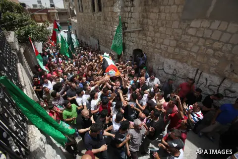 Mourners carry the body of Palestinian Jamal Dwikat, who died from wounds he sustained after he was shot during clashes with the Israeli army on Friday, during his funeral in the West Bank village of Balata Albalad near...