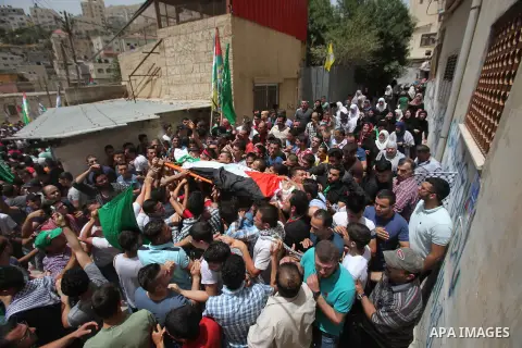 Mourners carry the body of Palestinian Jamal Dwikat, who died from wounds he sustained after he was shot during clashes with the Israeli army on Friday, during his funeral in the West Bank village of Balata Albalad near...