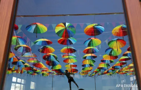 A Palestinian worker of a beachside café shop decorates its terrace with hanging colourful umbrellas as part of decorations for the Muslim holy fasting month of Ramadan in Gaza City, on June 9, 2016. Ramadan is sacred to...