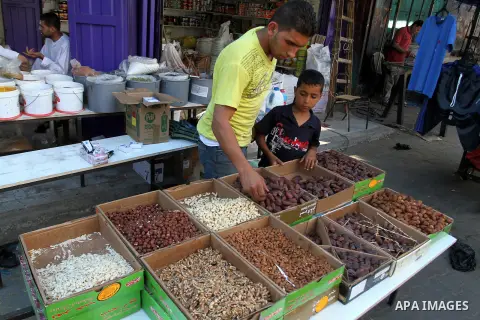 Palestinians shop at a market during the Muslim holy fasting month of Ramadan in Rafah in the southern Gaza strip, on June 9, 2016. Photo by Abed Rahim Khatib