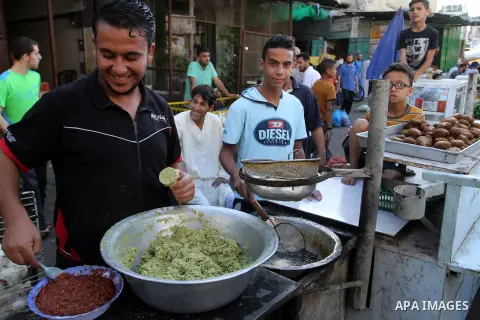 Palestinians shop at a market during the Muslim holy fasting month of Ramadan in Rafah in the southern Gaza strip, on June 9, 2016. Photo by Abed Rahim Khatib