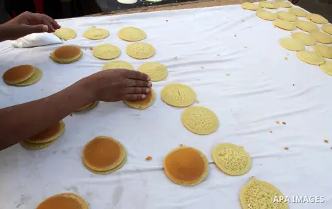 A Palestinian man prepares traditional pancakes known as ''Qatayef at a market during the Muslim holy fasting month of Ramadan in Rafah in the southern Gaza strip, on June 9, 2016. Photo by Abed Rahim Khatib