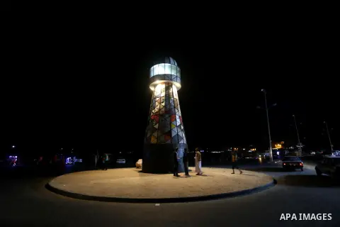 Palestinians walk around the lighthouse at the seaport of Gaza city, on June 10, 2016. Gaza lighthouse project depends on the recycling remnants of Israeli offensive on the Gaza Strip in 2014, for the Palestinian artist...