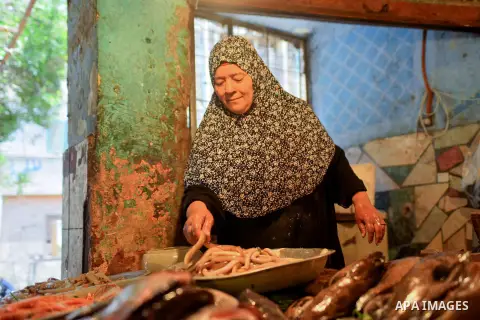 An Egyptian woman displays fishes at her shop on the holy month of Ramadan at a fishes market at the Imbaba area in Cairo, Egypt, on June 11, 2016. Ramadan is sacred to Muslims because it is during that month that tradit...