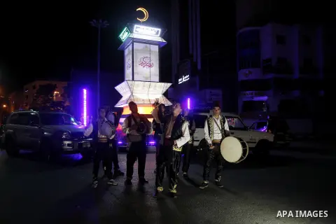 Palestinians dawn awakener "al-Musaharati" walk through streets to wake up Muslims for a meal before sunrise during the fasting month of Ramadan, in the West Bank city of Hebron city on June 12, 2016. Al-Musaharati is an...