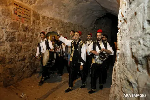 Palestinians dawn awakener "al-Musaharati" walk through streets to wake up Muslims for a meal before sunrise during the fasting month of Ramadan, in the West Bank city of Hebron city on June 12, 2016. Al-Musaharati is an...
