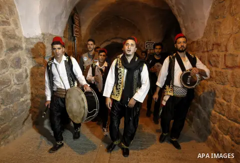 Palestinians dawn awakener "al-Musaharati" walk through streets to wake up Muslims for a meal before sunrise during the fasting month of Ramadan, in the West Bank city of Hebron city on June 12, 2016. Al-Musaharati is an...