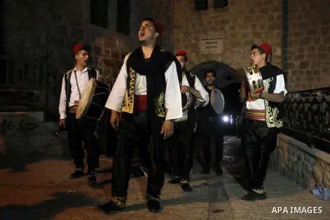 Palestinians dawn awakener "al-Musaharati" walk through streets to wake up Muslims for a meal before sunrise during the fasting month of Ramadan, in the West Bank city of Hebron city on June 12, 2016. Al-Musaharati is an...