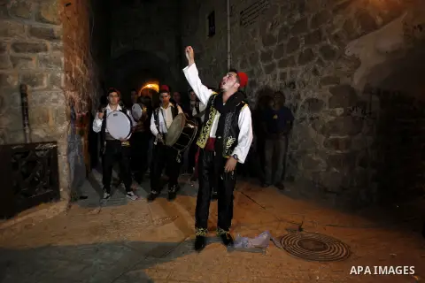 Palestinians dawn awakener "al-Musaharati" walk through streets to wake up Muslims for a meal before sunrise during the fasting month of Ramadan, in the West Bank city of Hebron city on June 12, 2016. Al-Musaharati is an...