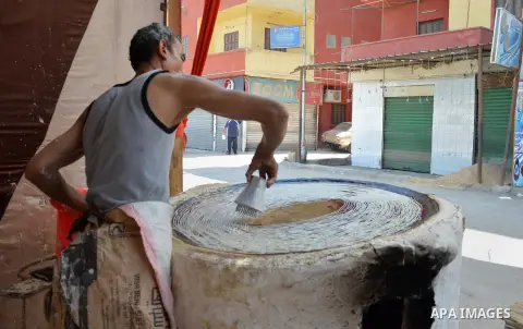 An Egyptian man prepares a traditional sweets "Konafa" on the holy month of Ramadan, in Cairo, Egypt, on June 12, 2016. Ramadan is sacred to Muslims because it is during that month that tradition says the Koran was revea...