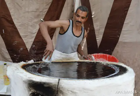 An Egyptian man prepares a traditional sweets "Konafa" on the holy month of Ramadan, in Cairo, Egypt, on June 12, 2016. Ramadan is sacred to Muslims because it is during that month that tradition says the Koran was revea...