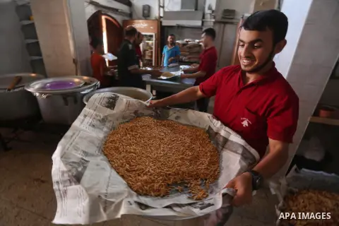 Palestinians prepare rice and meats as they wait for customers several hours before Iftar, the breaking of the day long Ramadan fast in Gaza City, on June 12, 2016. Muslims around the world refrain from eating, drinking...