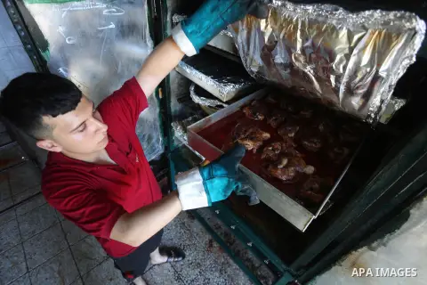 Palestinians prepare rice and meats as they wait for customers several hours before Iftar, the breaking of the day long Ramadan fast in Gaza City, on June 12, 2016. Muslims around the world refrain from eating, drinking...