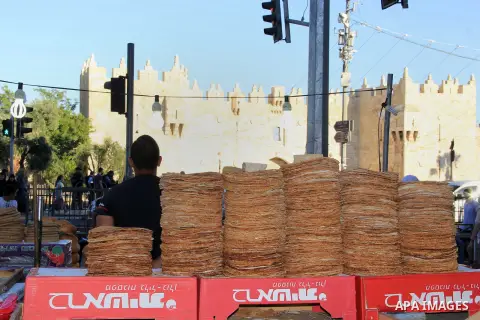 A Palestinian boy sells bread in front of Damascus gate during the Muslim holy fasting month of Ramadan in Jerusalem's old city on June, 12, 2016. Ramadan is sacred to Muslims because it is during that month that traditi...