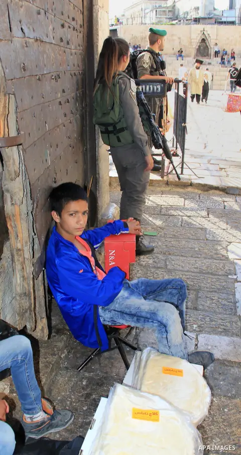 A Palestinian boy sells bread in front of Damascus gate during the Muslim holy fasting month of Ramadan in Jerusalem's old city on June, 12, 2016. Ramadan is sacred to Muslims because it is during that month that traditi...