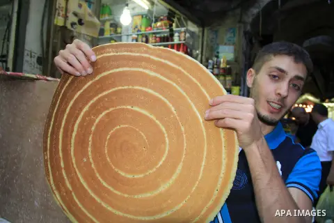 A Palestinian man prepares traditional pancakes known as ''Qatayef" at a market during the Muslim holy fasting month of Ramadan in Jerusalem's old city on June, 12, 2016. Ramadan is sacred to Muslims because it is during...