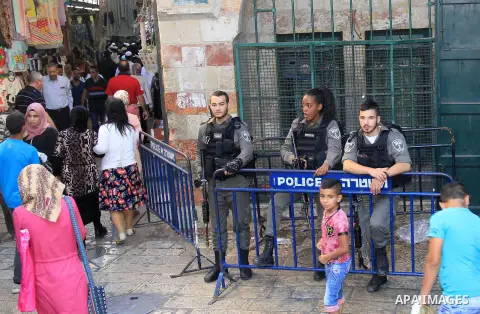 Israeli policemen stand guard as Palestinians shop at a market during the Muslim holy fasting month of Ramadan in Jerusalem's old city on June, 12, 2016. Ramadan is sacred to Muslims because it is during that month that...