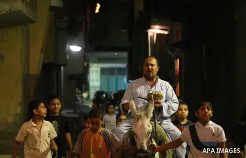 An Egyptian dawn awakener "al-Musaharati" ride a donkey through streets to wake up Muslims for a meal before sunrise during the fasting month of Ramadan, in Cairo, Egypt, on June 13, 2016. Al-Musaharati is an old profess...
