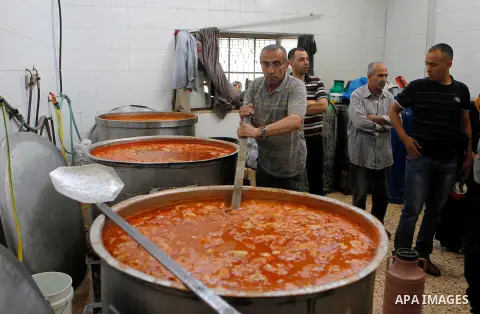 Palestinians prepare food to be distributed for free during the holy fasting month of Ramadan in the West Bank city of Hebron, 13 June 2016. the "Ibrahimi Takiya" was founded in 960 AD as an institute provides food for o...