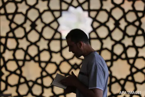 A Palestinian man sits reading the Koran, Islam's holy book, at the al-Khaldi mosque during the Muslim fasting month of Ramadan, in Gaza City on June 13, 2016. Photo by Mohammed Asad
