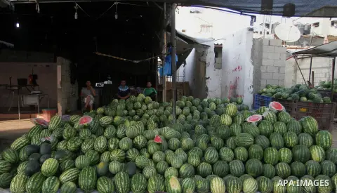 A Palestinian man displays watermelon at a market during the Muslim fasting month of Ramadan, in Rafah in the southern Gaza strip on June 13, 2016. Photo by Abed Rahim Khatib